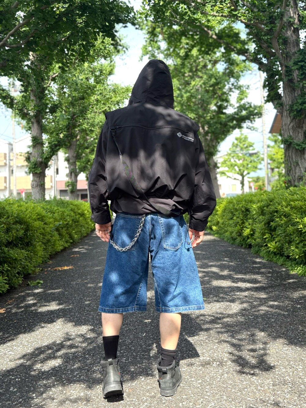 ブルー系のデニムパンツ、ブラック系のベスト、ブラック系のその他トップスを着用したメンズの夏コーディネートの3枚目の写真