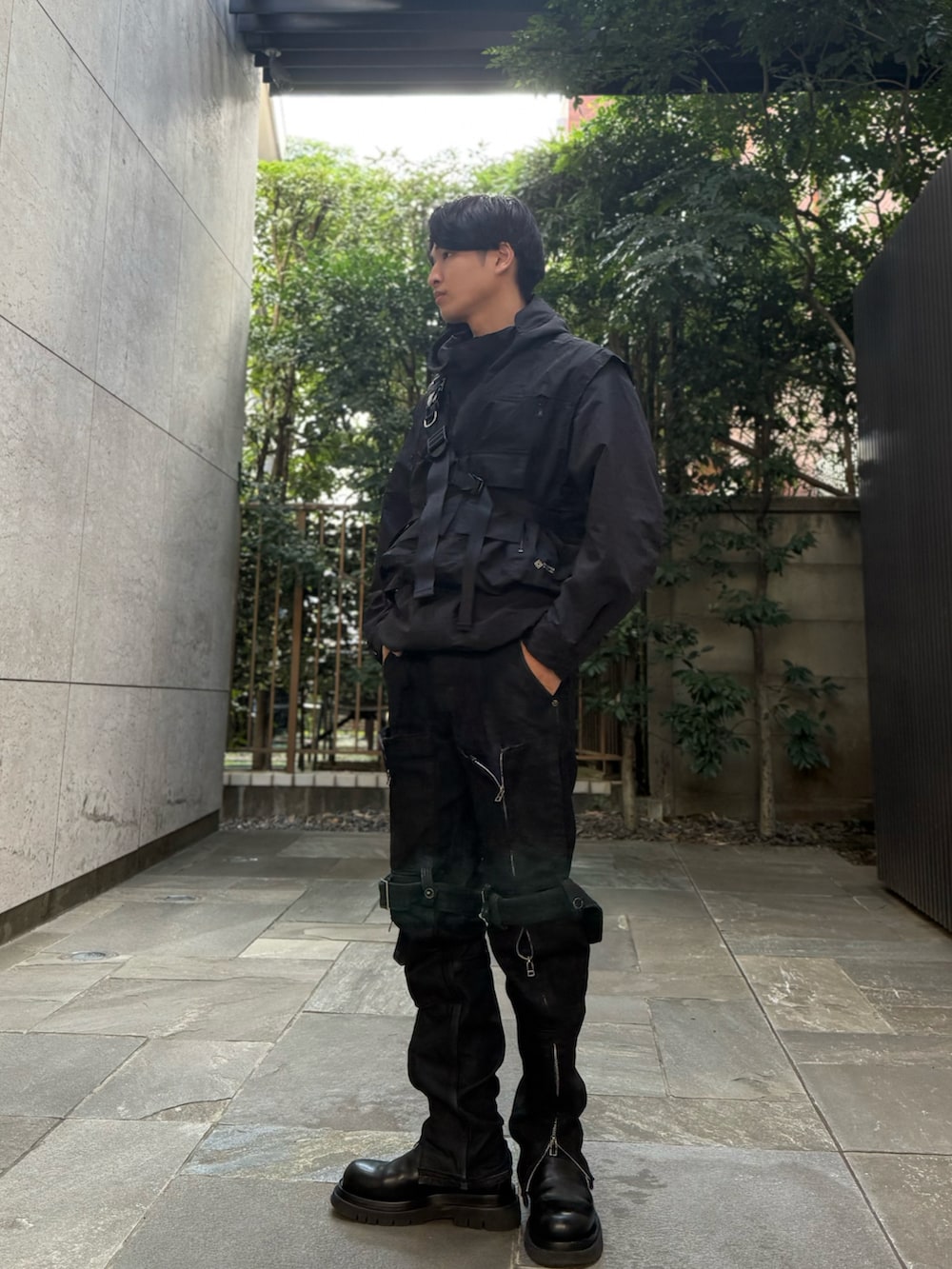 ブラック系のデニムパンツ、ブラック系のブーツ、ブラック系のベストを着用したメンズの秋コーディネートの3枚目の写真