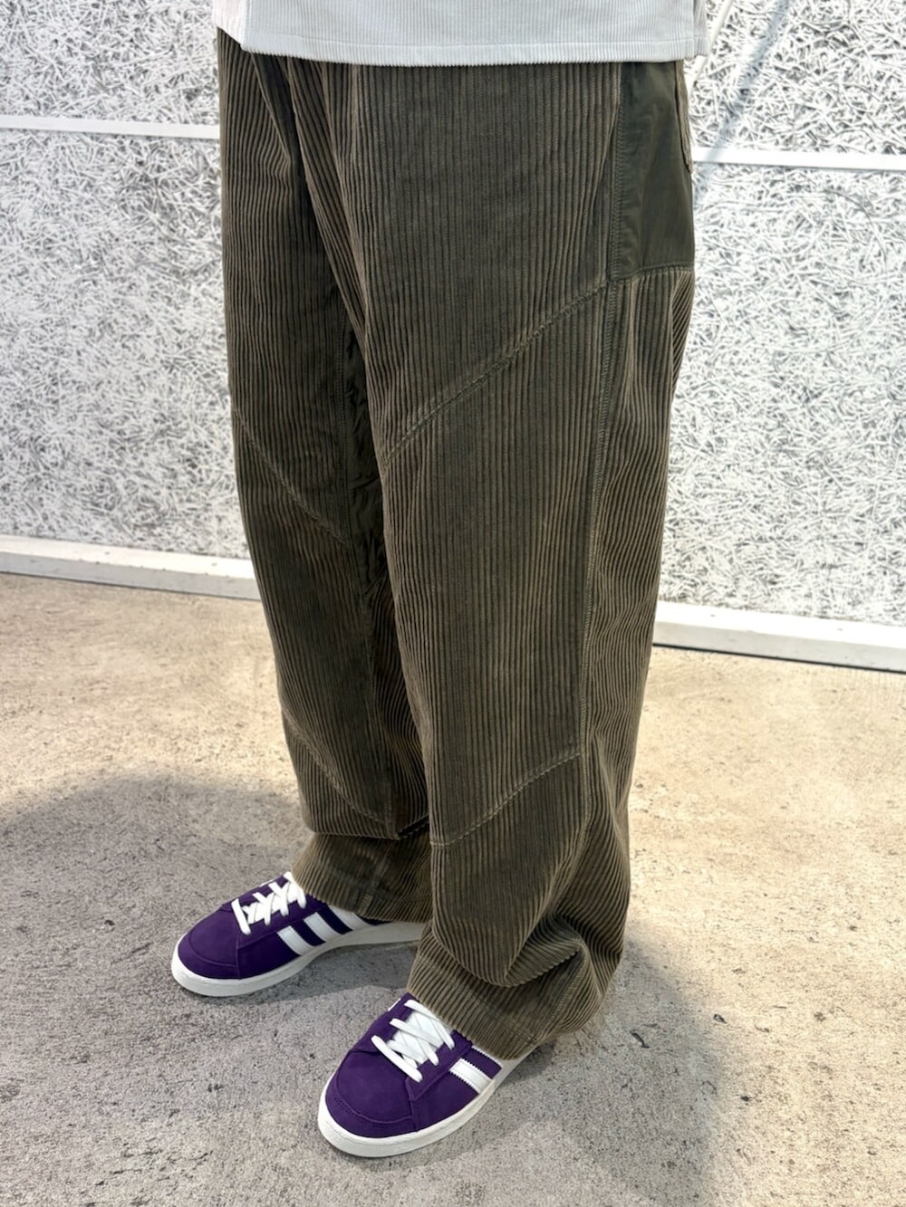 ホワイト系のTシャツ/カットソー、パープル系のスニーカー、グリーン系のキャップを着用したメンズの秋コーディネートの4枚目の写真