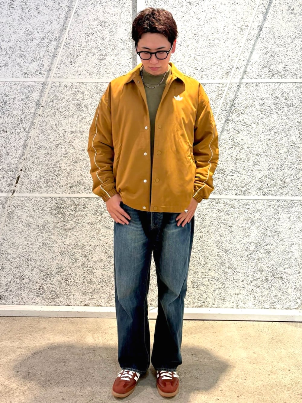 ブラウン系のブルゾン、グリーン系のトップス、ブラウン系のスニーカーを着用したメンズの秋コーディネートの2枚目の写真