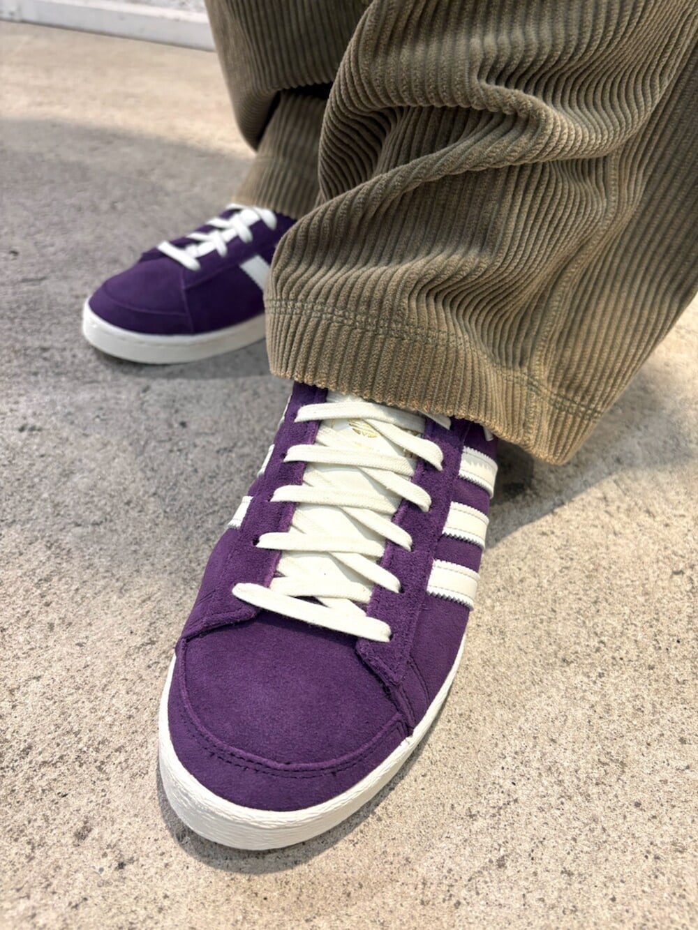 ホワイト系のTシャツ/カットソー、パープル系のスニーカー、グリーン系のキャップを着用したメンズの秋コーディネートの5枚目の写真