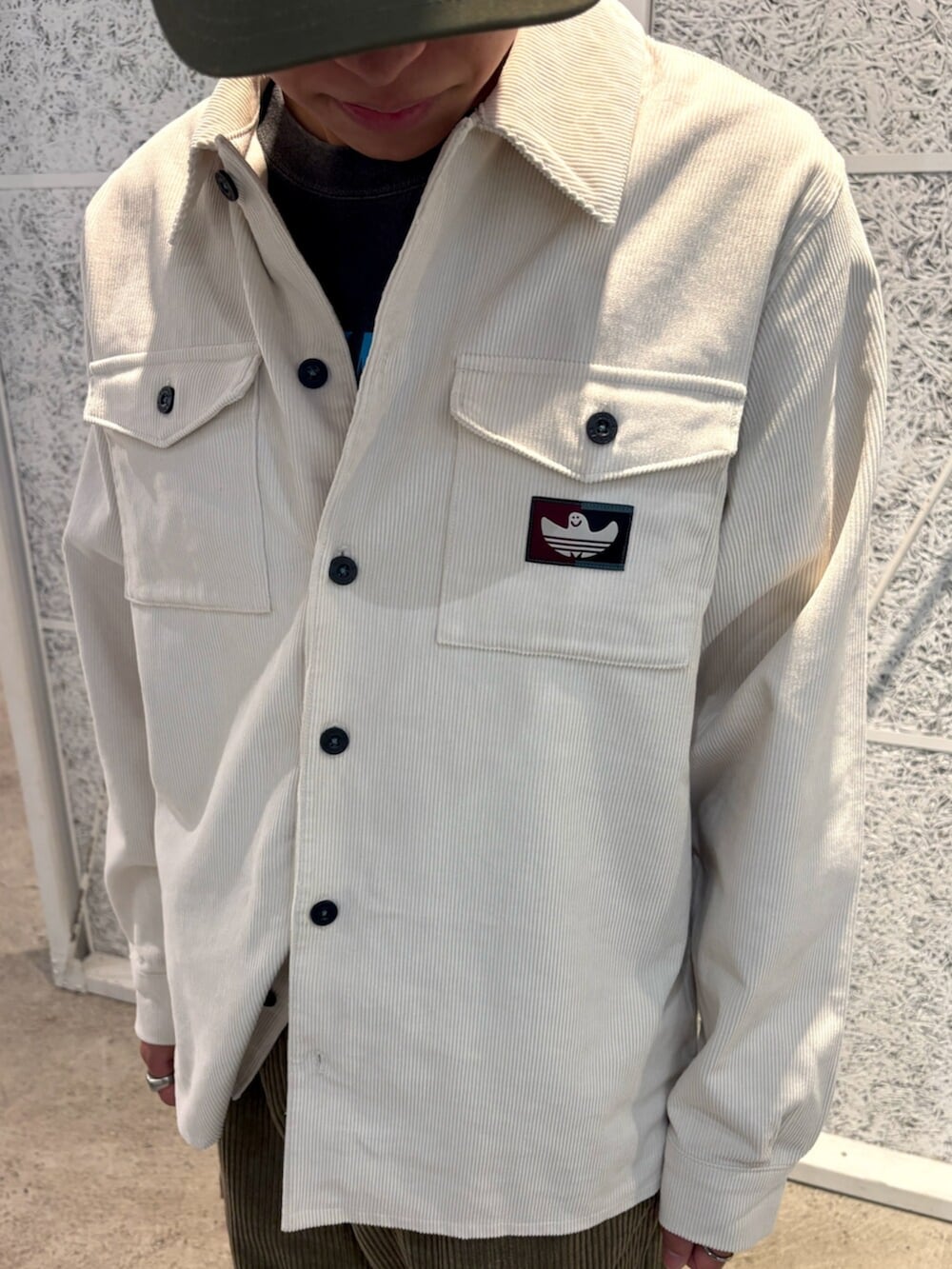 ホワイト系のTシャツ/カットソー、パープル系のスニーカー、グリーン系のキャップを着用したメンズの秋コーディネートの3枚目の写真