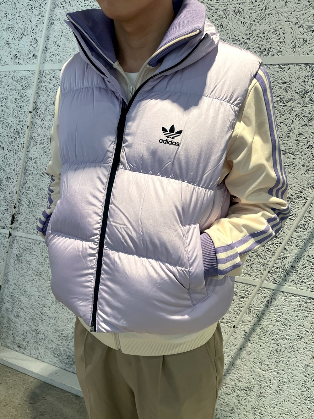 パープル系のダウンベスト、ホワイト系のジャージを着用したメンズの冬コーディネートの3枚目の写真