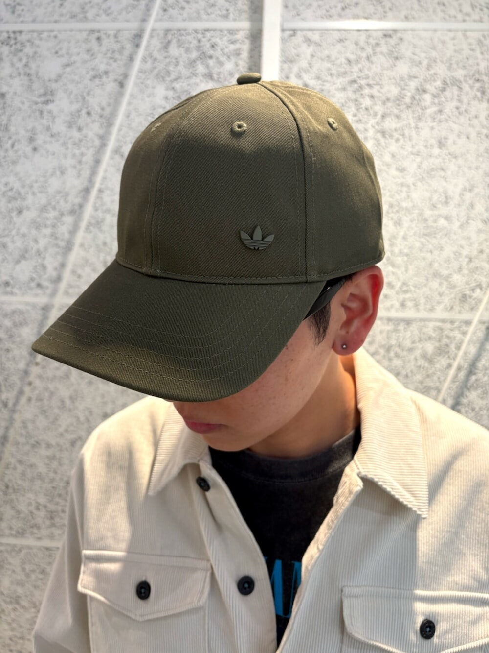 ホワイト系のTシャツ/カットソー、パープル系のスニーカー、グリーン系のキャップを着用したメンズの秋コーディネートの6枚目の写真