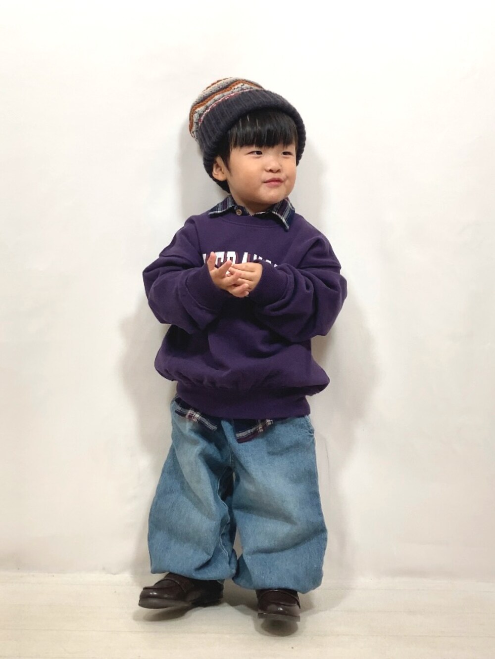 パープル系のスウェット、ブルー系のシャツ/ブラウス、ブルー系のデニムパンツを着用したキッズの秋コーディネートの3枚目の写真