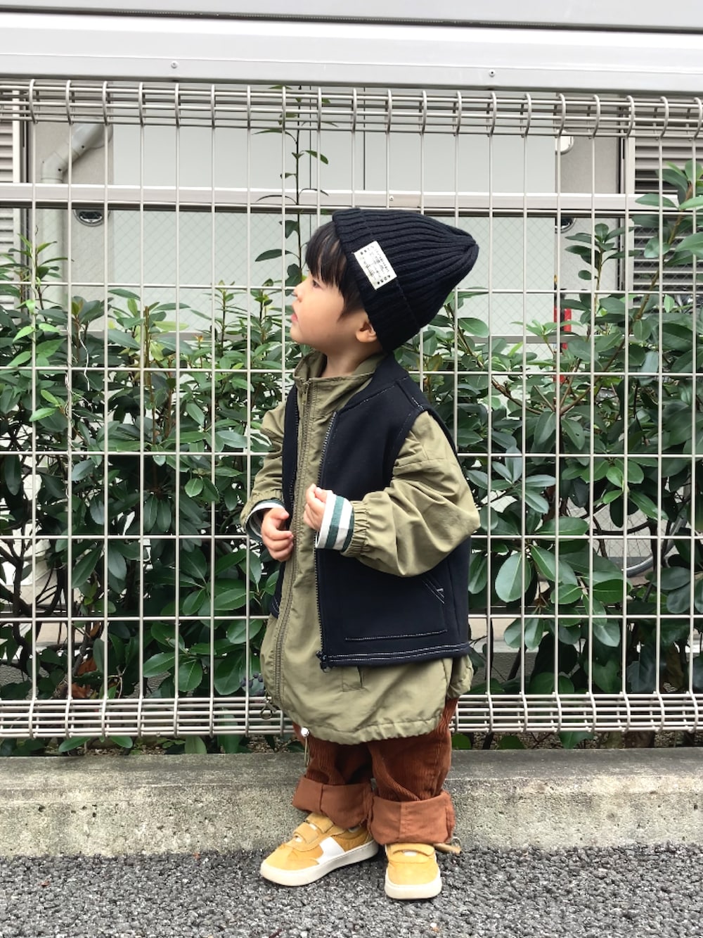 グリーン系のジャケット/アウター、ブラック系のベスト、グリーン系のTシャツ/カットソーを着用したキッズの秋コーディネートの5枚目の写真