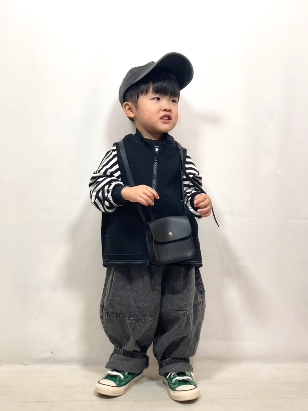 ブラック系のベスト、ブラック系のTシャツ/カットソー、ブラック系のデニムパンツを着用したキッズの秋コーディネートの5枚目の写真