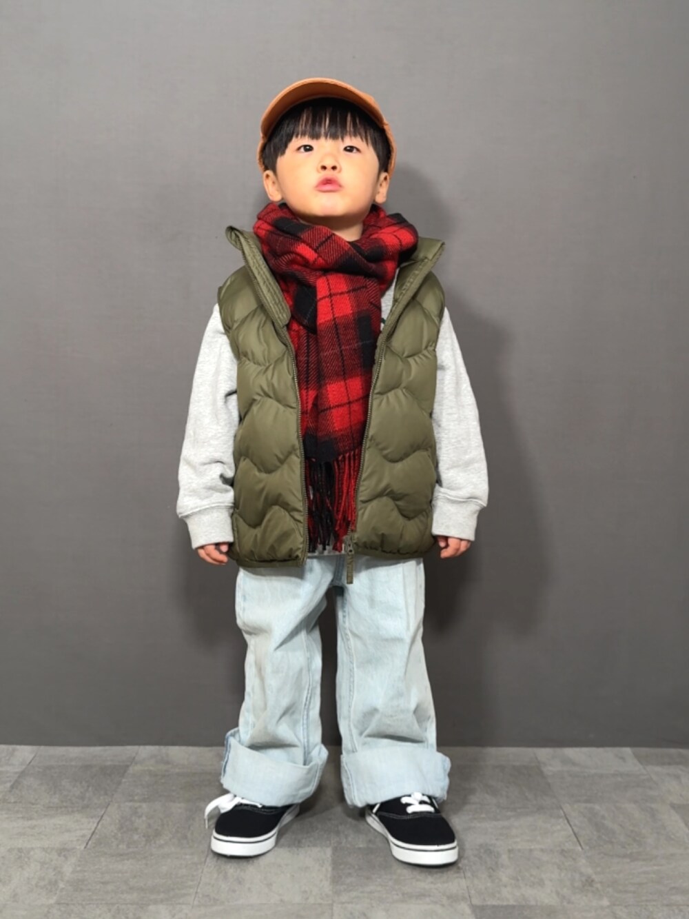 グレー系のスウェット、グリーン系のベスト、ブルー系のデニムパンツを着用したキッズの冬コーディネートの4枚目の写真