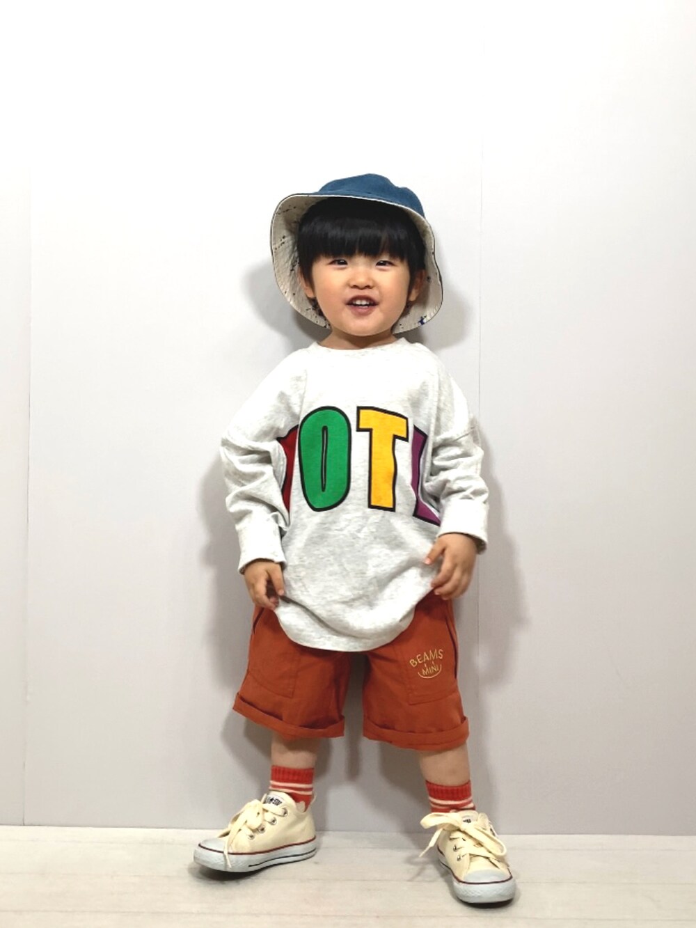 グレー系のTシャツ/カットソー、オレンジ系のその他パンツ、ホワイト系のスニーカーを着用したキッズの春コーディネートの2枚目の写真