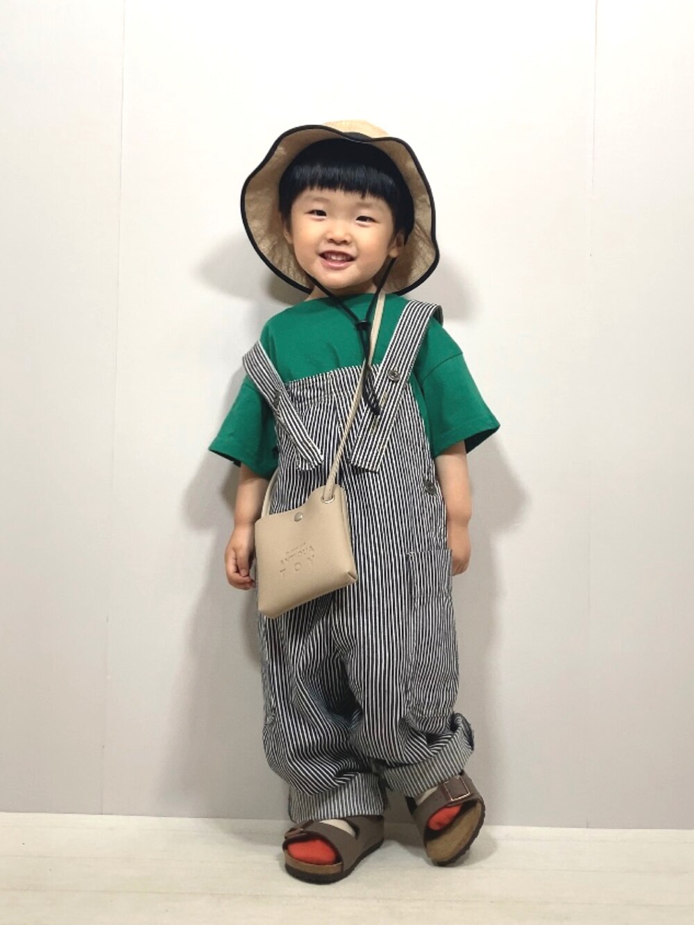 グリーン系のTシャツ/カットソー、その他のサロペット/オーバーオール、ベージュ系のショルダーバッグを着用したキッズの夏コーディネートの3枚目の写真