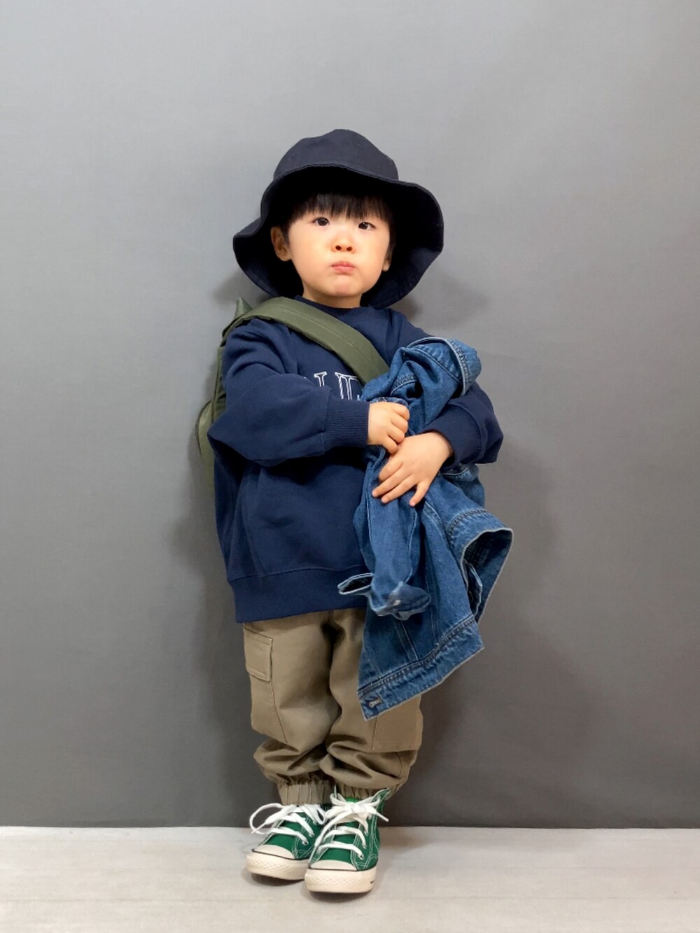 ブルー系のデニムジャケット、ブルー系のスウェット、ベージュ系のパンツを着用したキッズの冬コーディネートの2枚目の写真