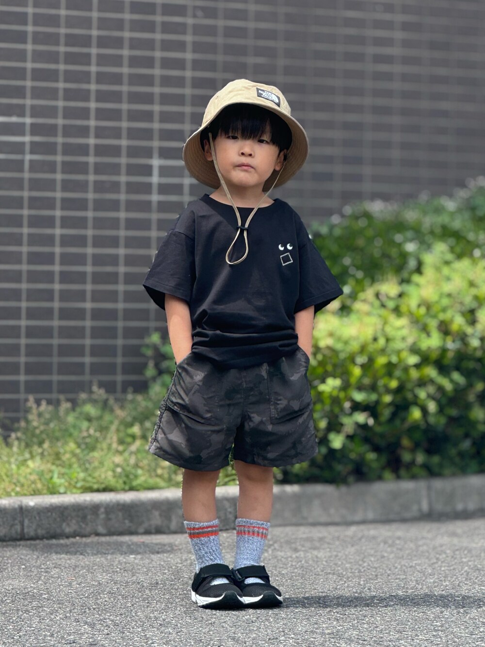 ブラック系のTシャツ/カットソー、グレー系のパンツ、ブラック系のサンダルを着用したキッズの夏コーディネートの2枚目の写真