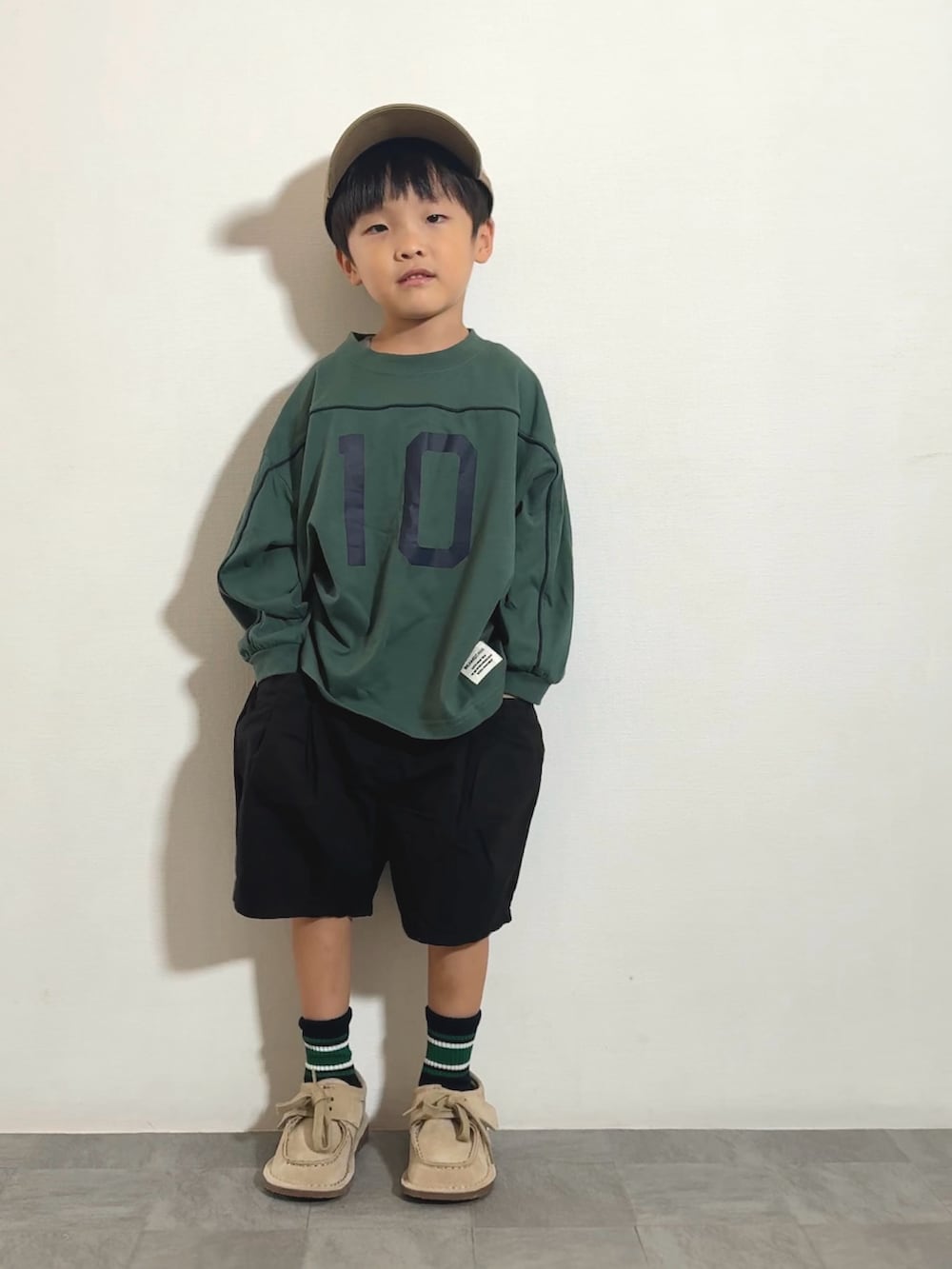 ブラック系のその他パンツ、ベージュ系のモカシン/デッキシューズ、グリーン系のTシャツ/カットソーを着用したキッズの秋コーディネートの2枚目の写真