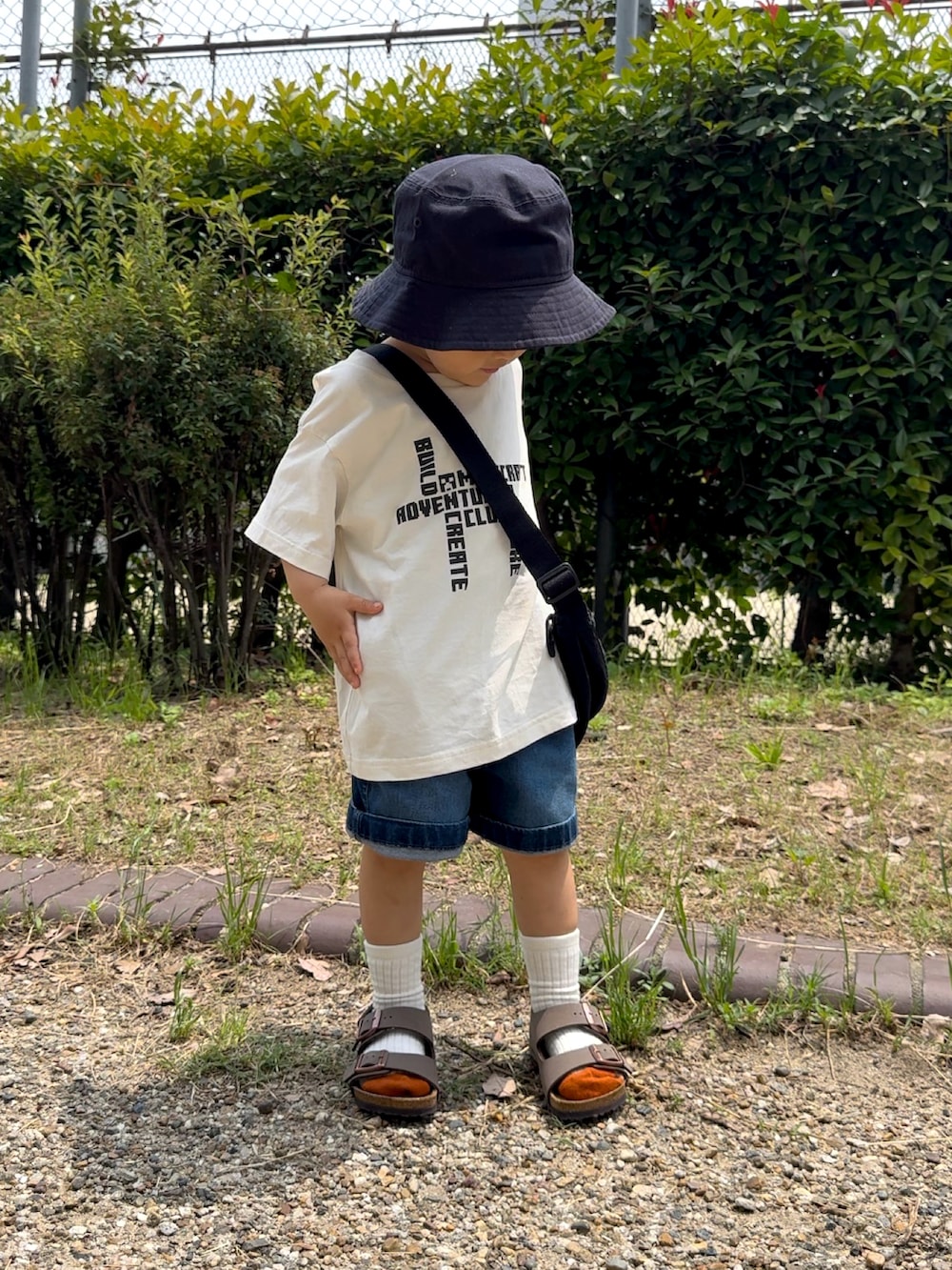 ホワイト系のTシャツ/カットソー、ブルー系のデニムパンツ、ブラック系のショルダーバッグを着用したキッズの夏コーディネートの3枚目の写真