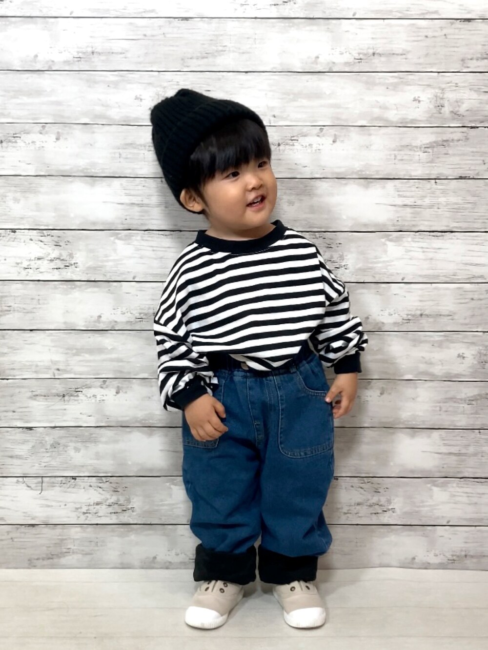 ブラック系のTシャツ/カットソー、ブルー系のデニムパンツ、ベージュ系のシューズを着用したキッズの秋コーディネートの2枚目の写真