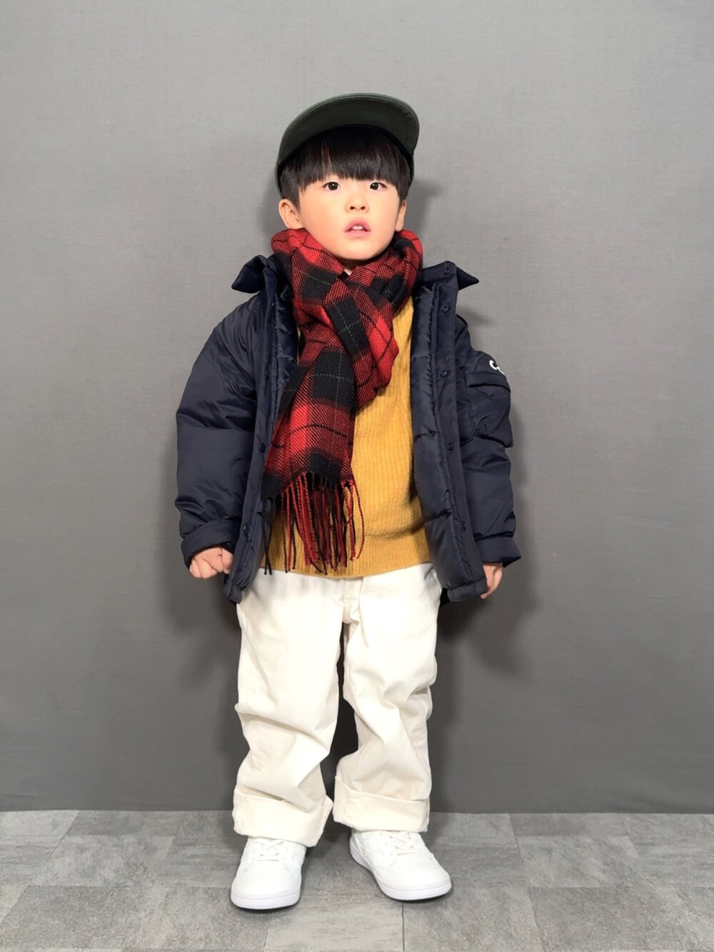 ブルー系のジャケット/アウター、イエロー系のニット/セーター、ホワイト系のパンツを着用したキッズの冬コーディネートの2枚目の写真