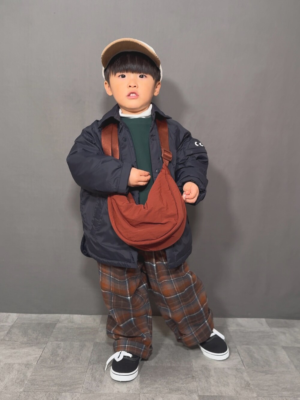 ブルー系のジャケット/アウター、グリーン系のスウェット、ホワイト系のTシャツ/カットソーを着用したキッズの冬コーディネートの2枚目の写真