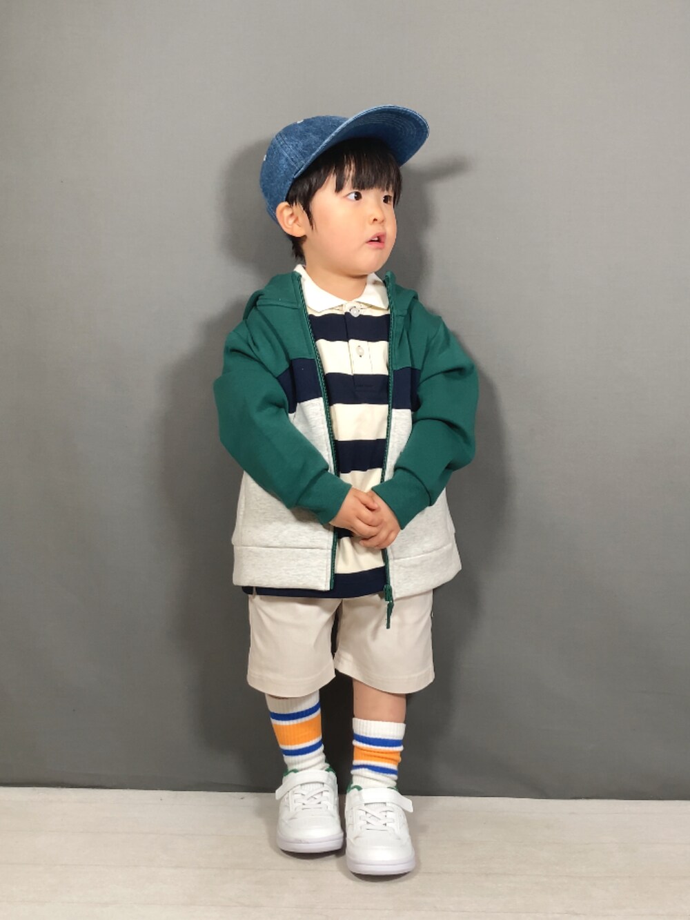 グリーン系のパーカー、ベージュ系のトップス、ホワイト系のその他パンツを着用したキッズの春コーディネートの3枚目の写真