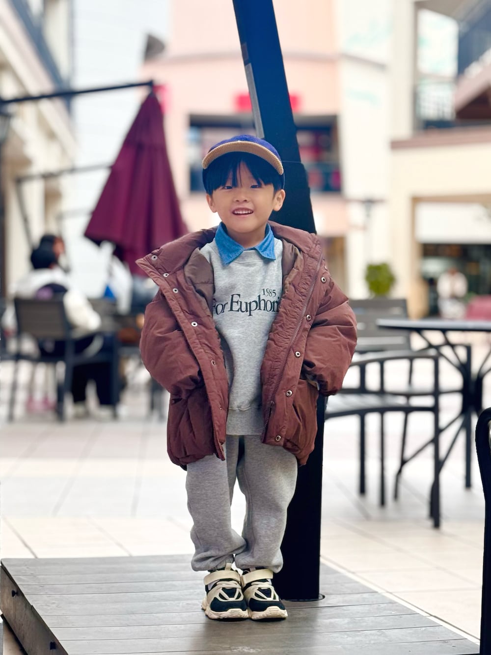グレー系のスウェット、ブラウン系のダウンジャケット/コート、グレー系のスウェットパンツを着用したキッズの冬コーディネートの3枚目の写真