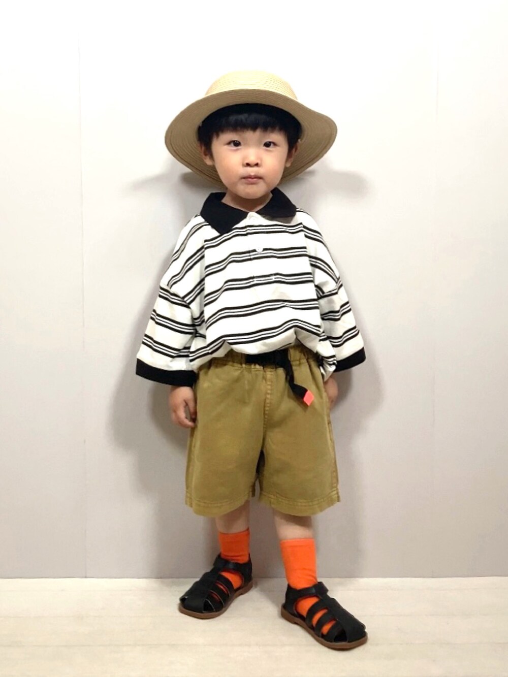 ベージュ系のポロシャツ、イエロー系のその他パンツ、ブラック系のサンダルを着用したキッズの夏コーディネートの3枚目の写真