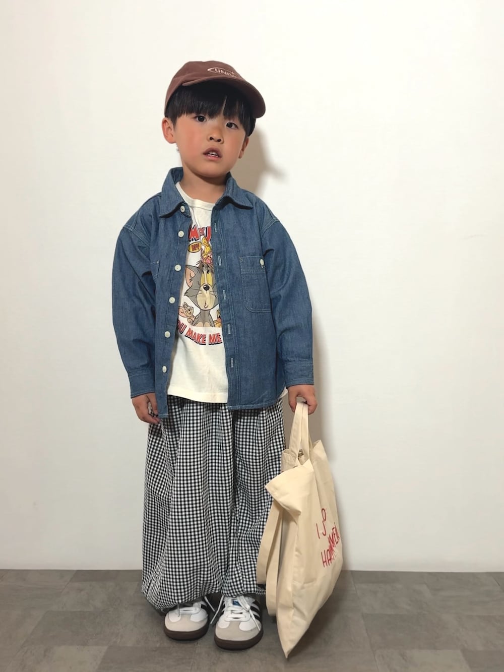 ブラック系のその他パンツ、ベージュ系のトートバッグ、ホワイト系のTシャツ/カットソーを着用したキッズの春コーディネートの2枚目の写真