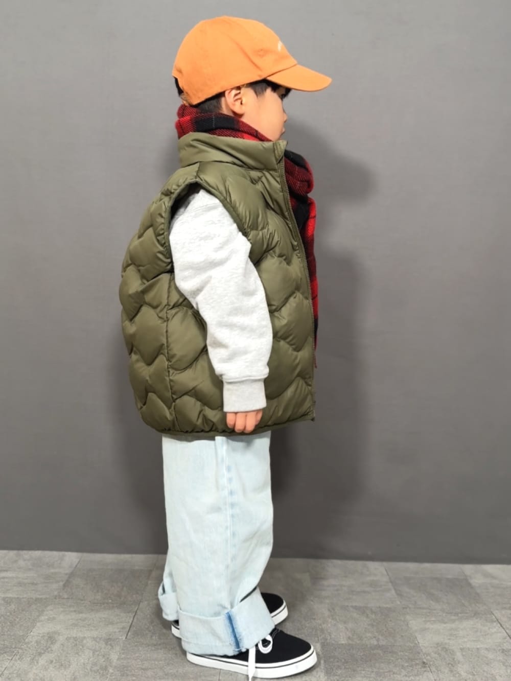 グレー系のスウェット、グリーン系のベスト、ブルー系のデニムパンツを着用したキッズの冬コーディネートの5枚目の写真