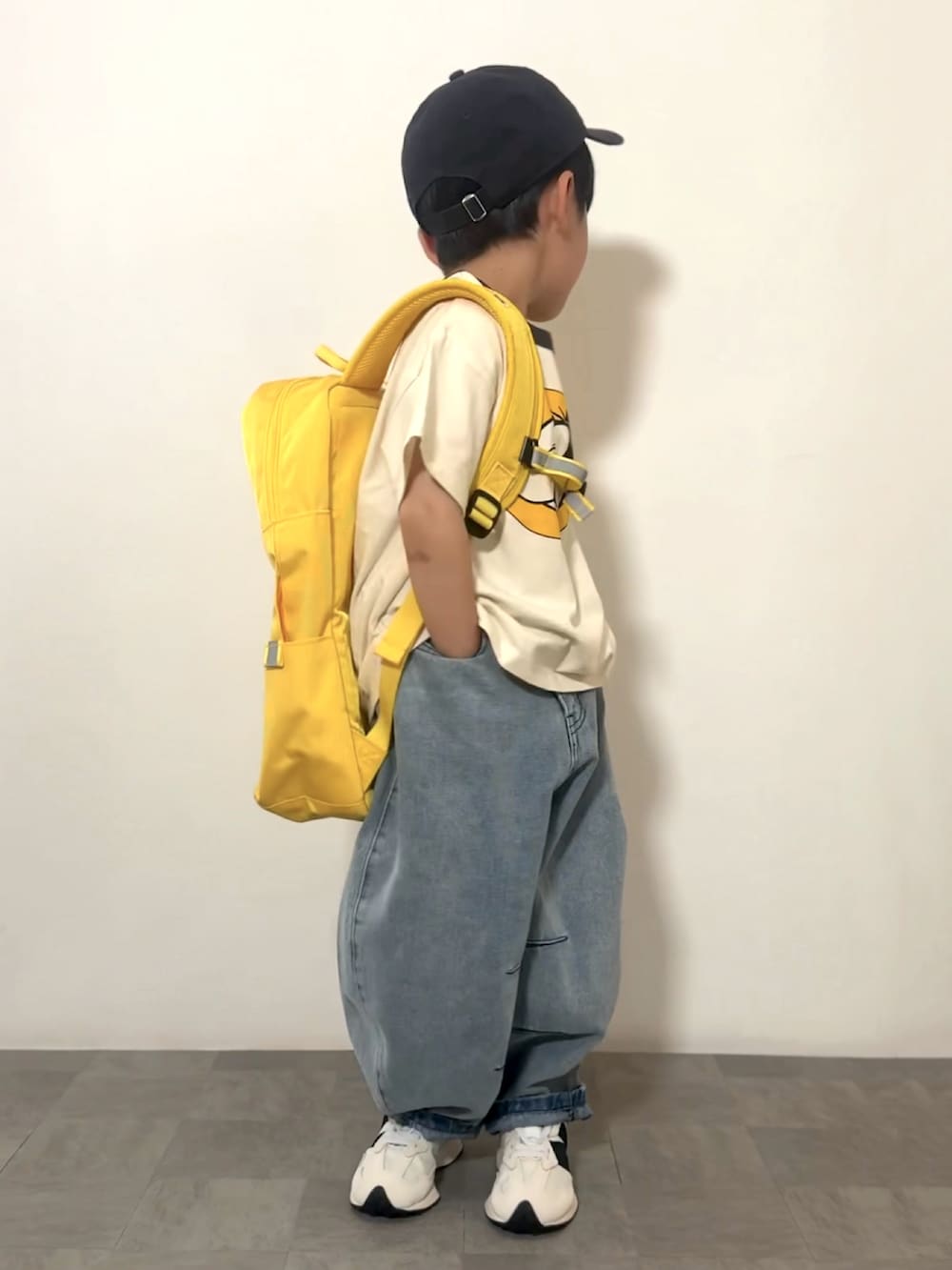 ブルー系のデニムパンツ、ホワイト系のスニーカー、ホワイト系のTシャツ/カットソーを着用したキッズの春コーディネートの2枚目の写真