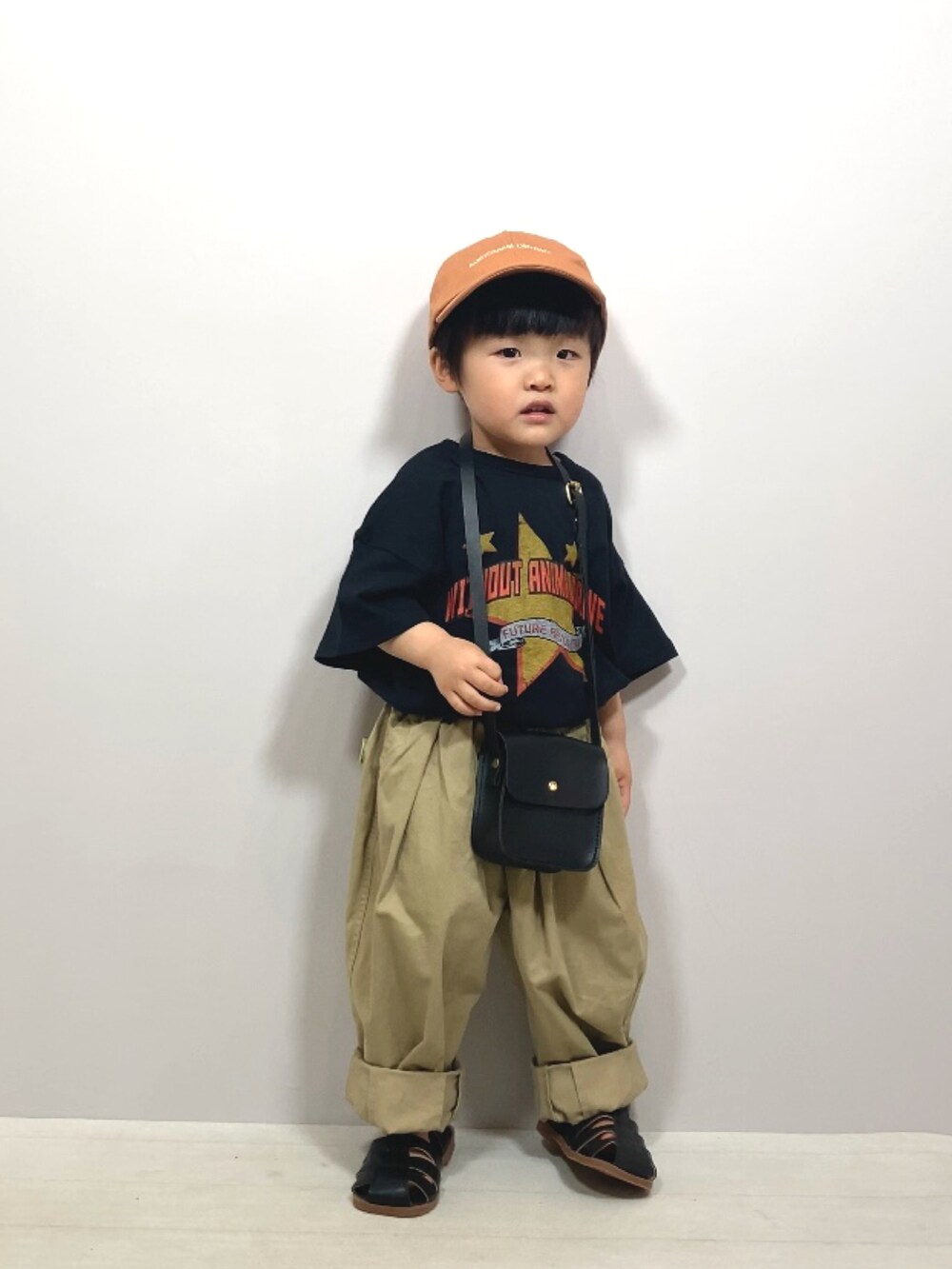 ブラック系のTシャツ/カットソー、ベージュ系のその他パンツ、ブラック系のショルダーバッグを着用したキッズの春コーディネートの5枚目の写真