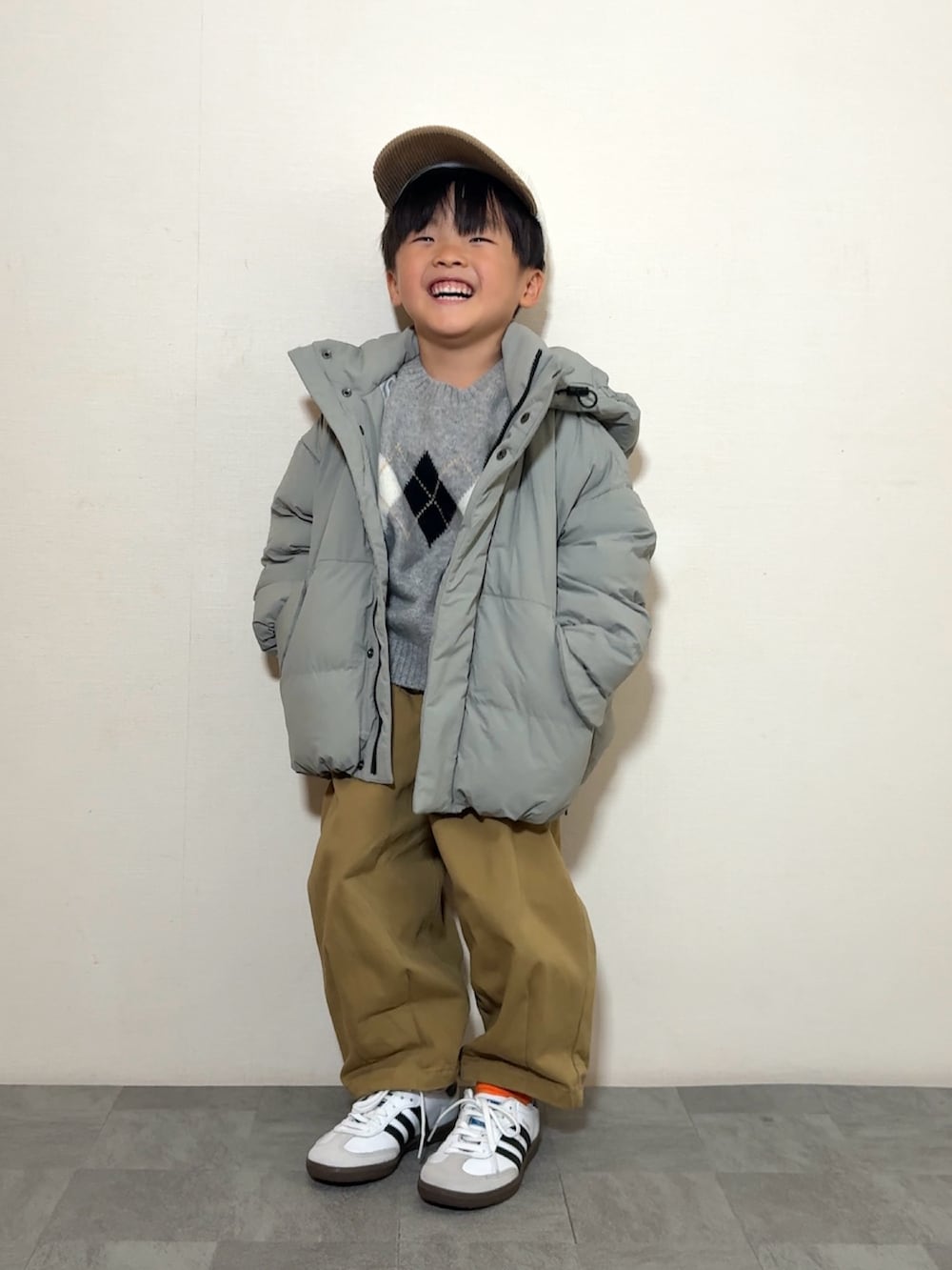 ブラウン系のその他パンツ、ホワイト系のスニーカー、グリーン系のブルゾンを着用したキッズの秋コーディネートの2枚目の写真