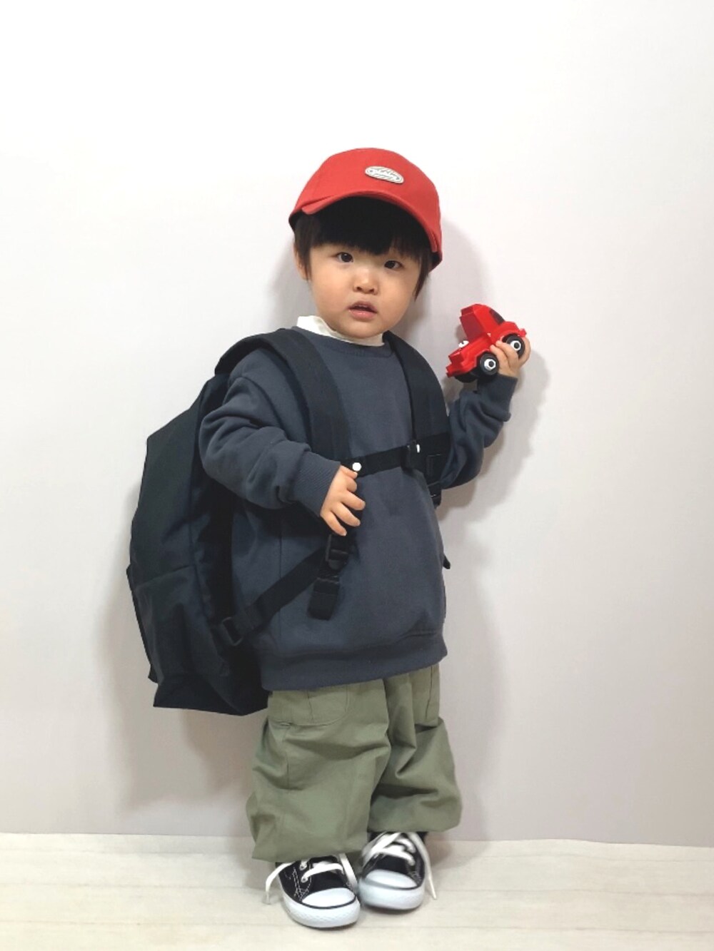 グレー系のスウェット、ホワイト系のTシャツ/カットソー、グリーン系のカーゴパンツを着用したキッズの冬コーディネートの2枚目の写真