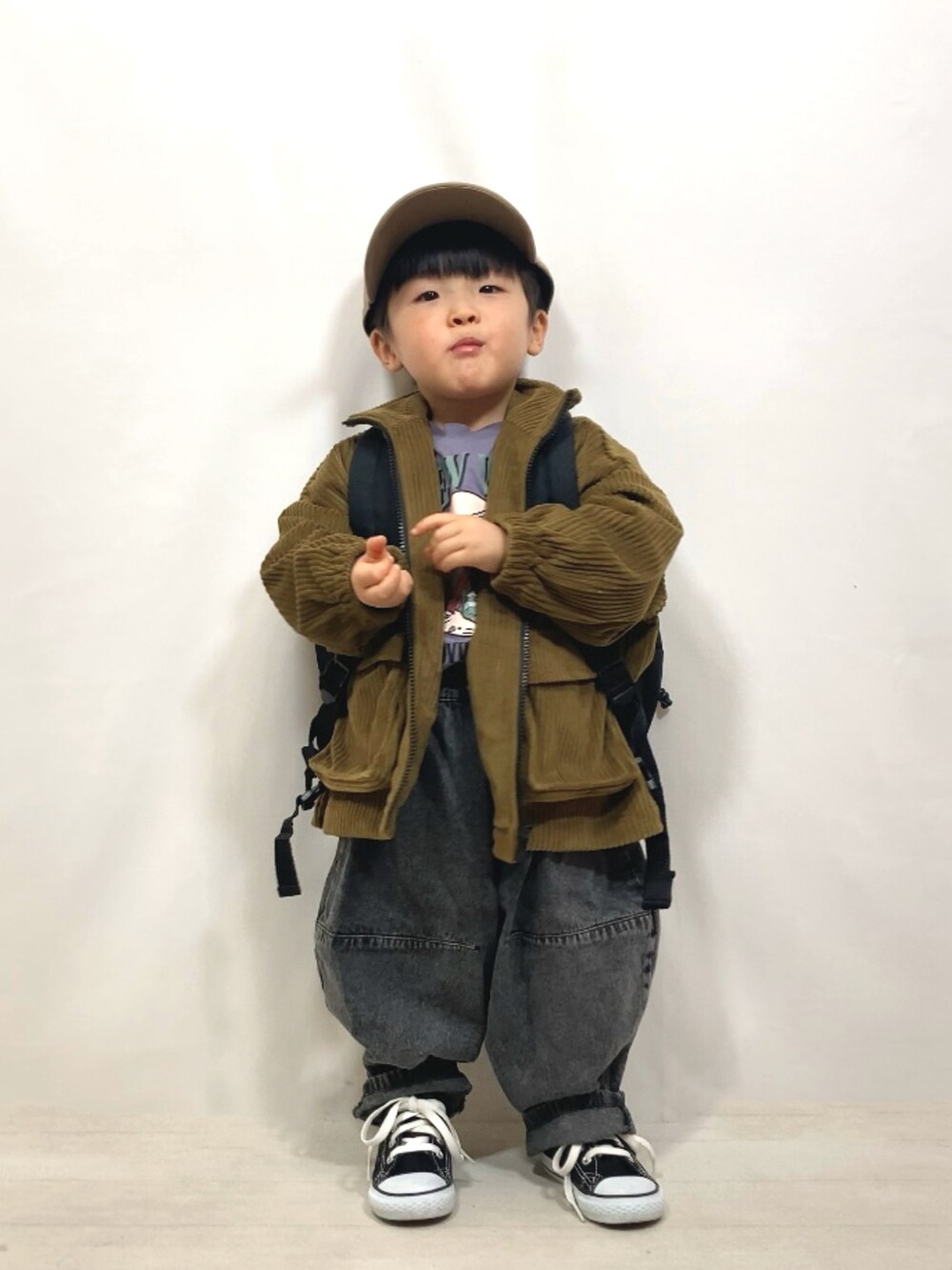 グリーン系のブルゾン、パープル系のTシャツ/カットソー、ブラック系のデニムパンツを着用したキッズの冬コーディネートの4枚目の写真