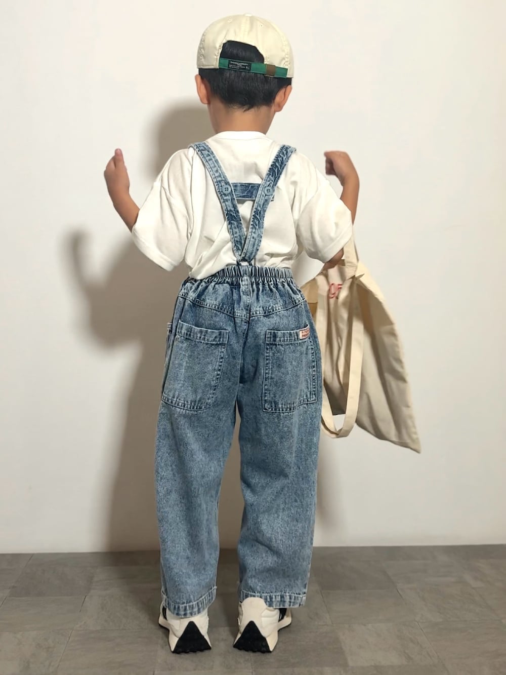 ホワイト系のTシャツ/カットソー、ブルー系のデニムパンツ、ベージュ系のトートバッグを着用したキッズの夏コーディネートの4枚目の写真