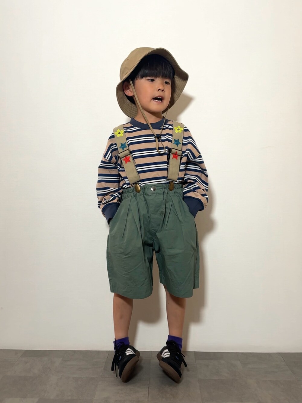 ブルー系のTシャツ/カットソー、ブラック系のスニーカー、グリーン系のその他パンツを着用したキッズの春コーディネートの2枚目の写真