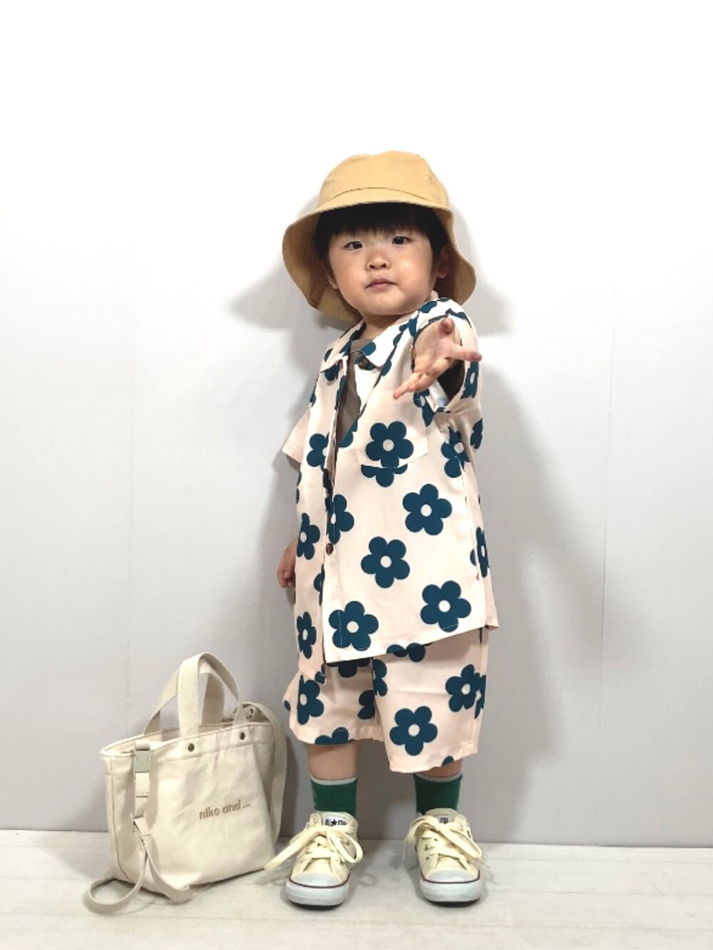 ベージュ系のセットアップ、グリーン系のTシャツ/カットソー、ホワイト系のスニーカーを着用したキッズの春コーディネートの3枚目の写真