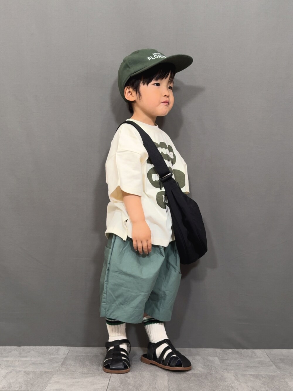 ブラック系のTシャツ/カットソー、グリーン系のその他パンツ、ブラック系のショルダーバッグを着用したキッズの春コーディネートの3枚目の写真