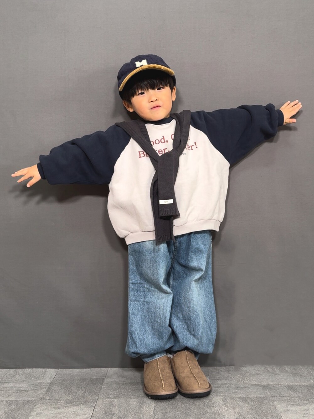 グレー系のスウェット、ブルー系のデニムパンツ、イエロー系のブーツを着用したキッズの冬コーディネートの2枚目の写真