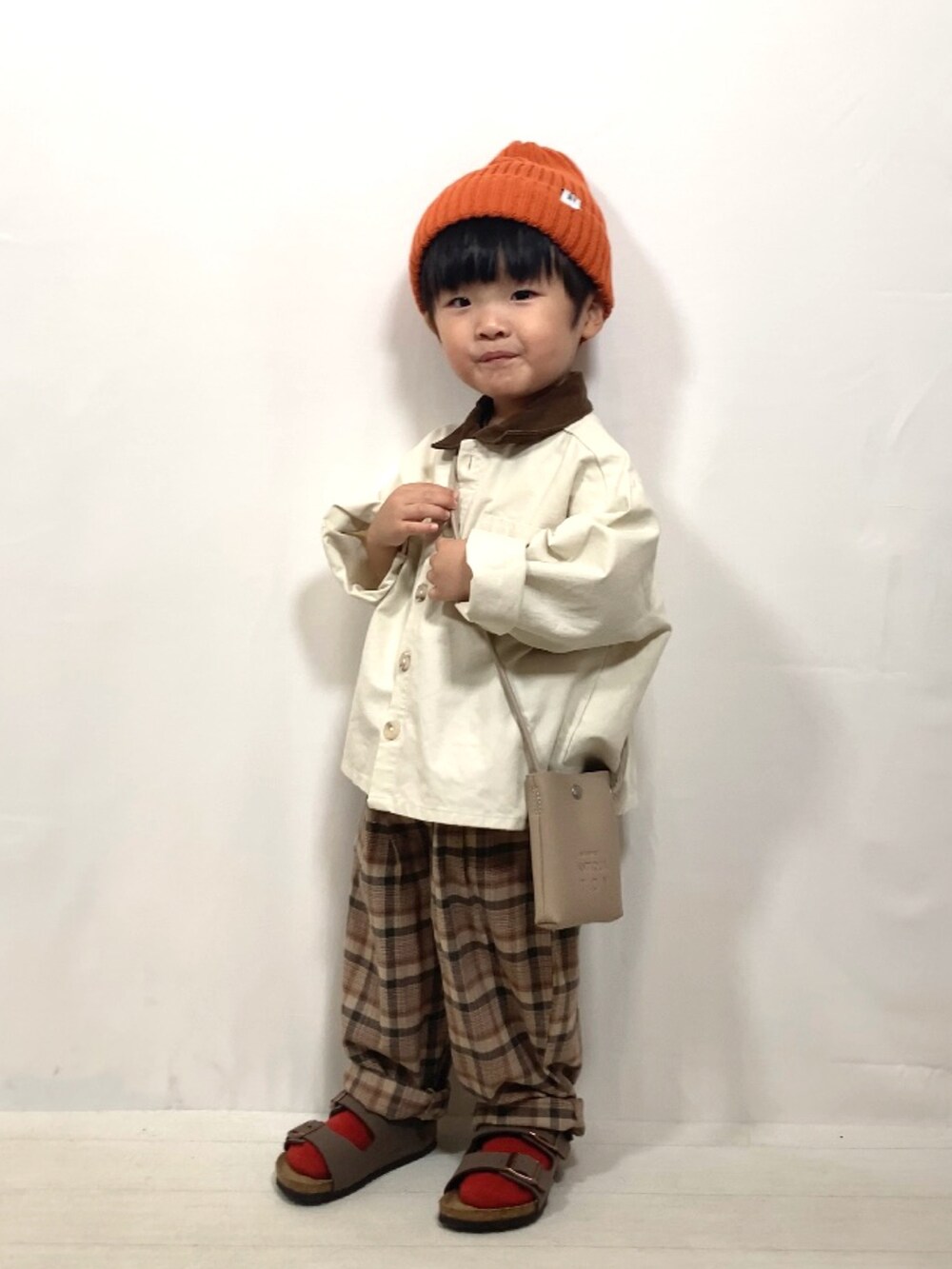 ホワイト系のジャケット/アウター、ブラウン系のパンツ、ベージュ系のショルダーバッグを着用したキッズの秋コーディネートの5枚目の写真