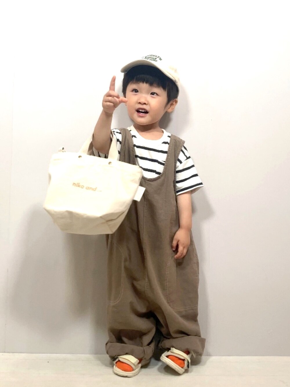 ホワイト系のTシャツ/カットソー、ブラウン系のオールインワン・サロペット、ホワイト系のショルダーバッグを着用したキッズの夏コーディネートの3枚目の写真