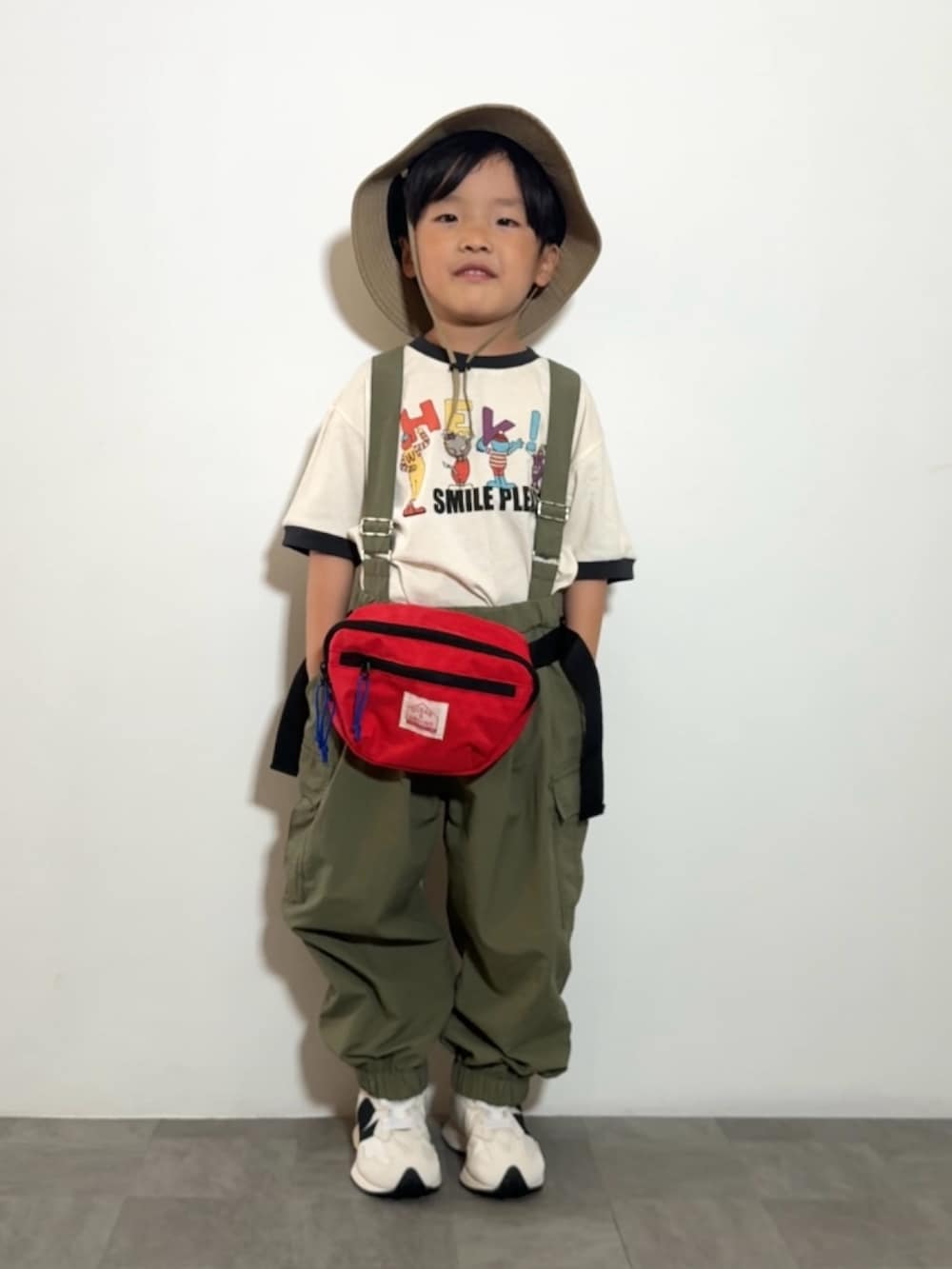ホワイト系のTシャツ/カットソー、レッド系のボディバッグ/ウエストポーチ、ホワイト系のスニーカーを着用したキッズの春コーディネートの3枚目の写真