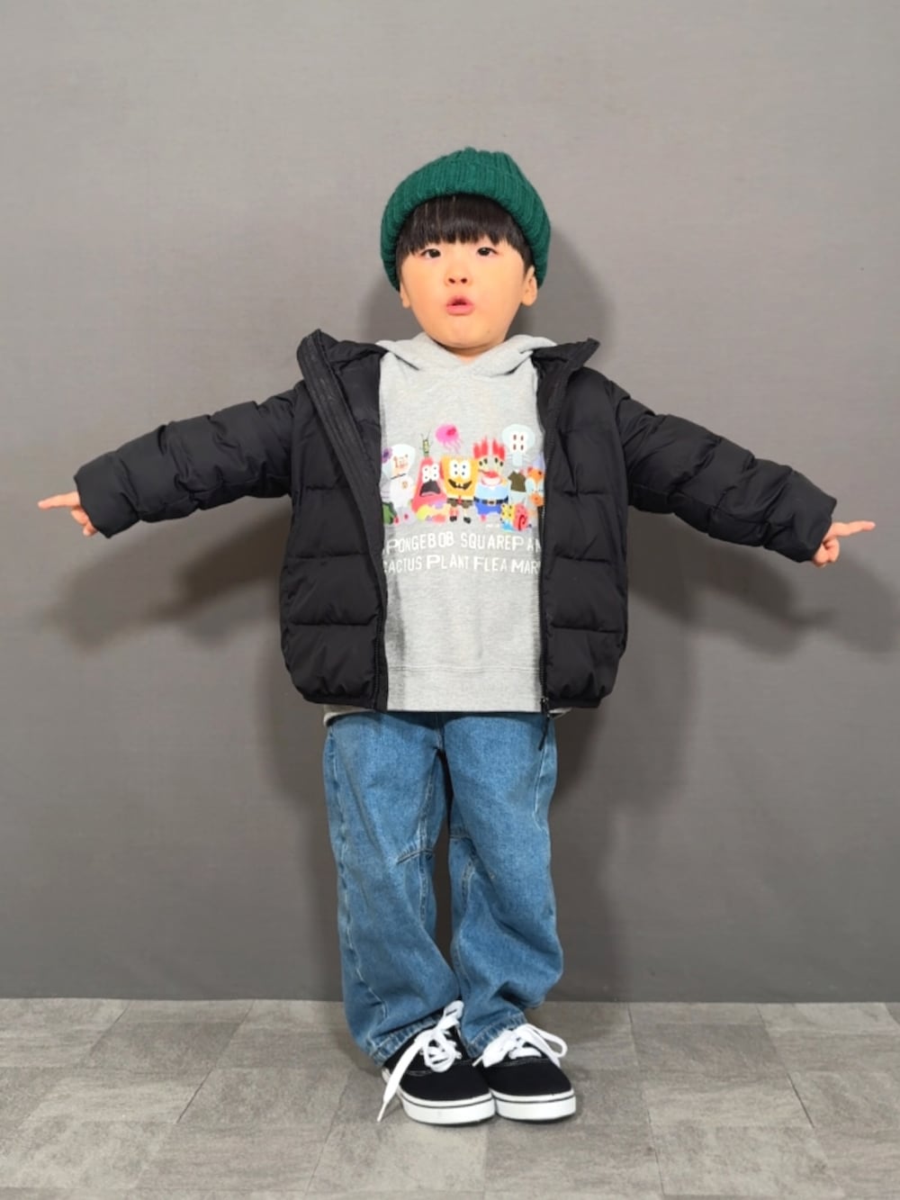 ブラック系のダウンジャケット/コート、グレー系のスウェット、ブルー系のデニムパンツを着用したキッズの冬コーディネートの2枚目の写真