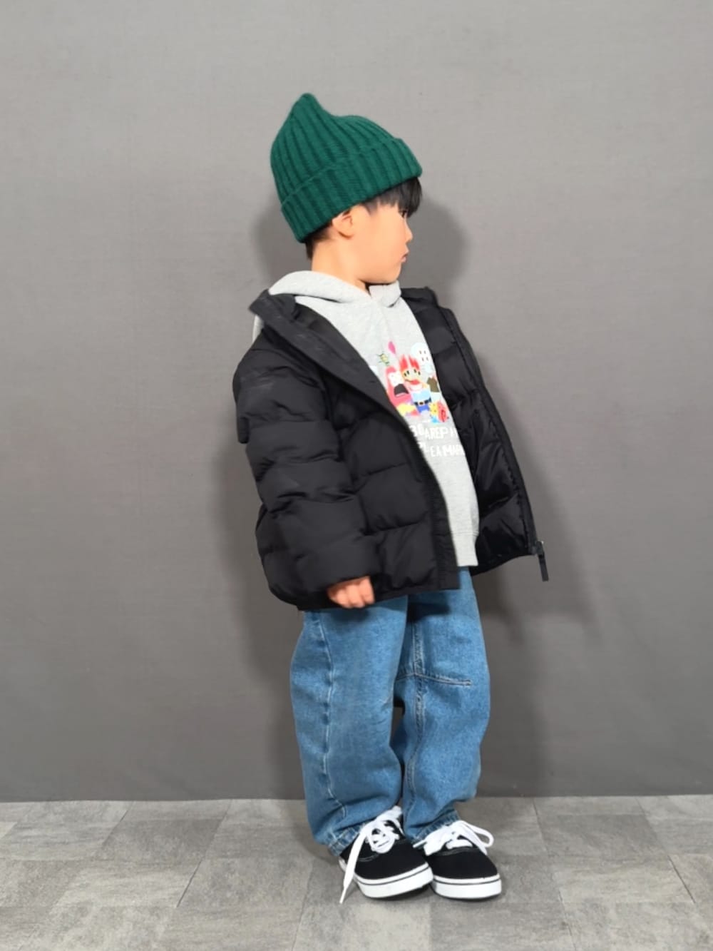 ブラック系のダウンジャケット/コート、グレー系のスウェット、ブルー系のデニムパンツを着用したキッズの冬コーディネートの5枚目の写真
