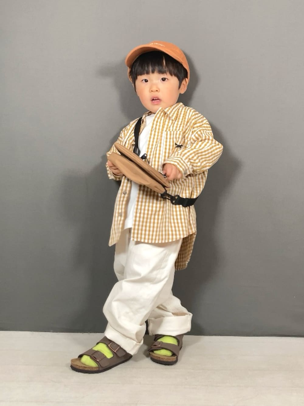 イエロー系のシャツ/ブラウス、グリーン系のTシャツ/カットソー、ホワイト系のパンツを着用したキッズの春コーディネートの4枚目の写真