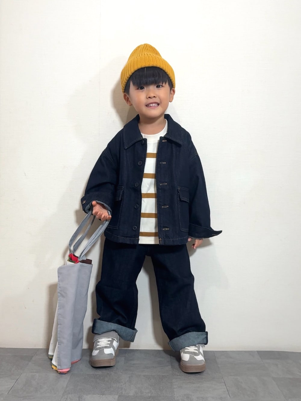 イエロー系のTシャツ/カットソー、ブルー系のデニムジャケット、ブルー系のデニムパンツを着用したキッズの秋コーディネートの3枚目の写真