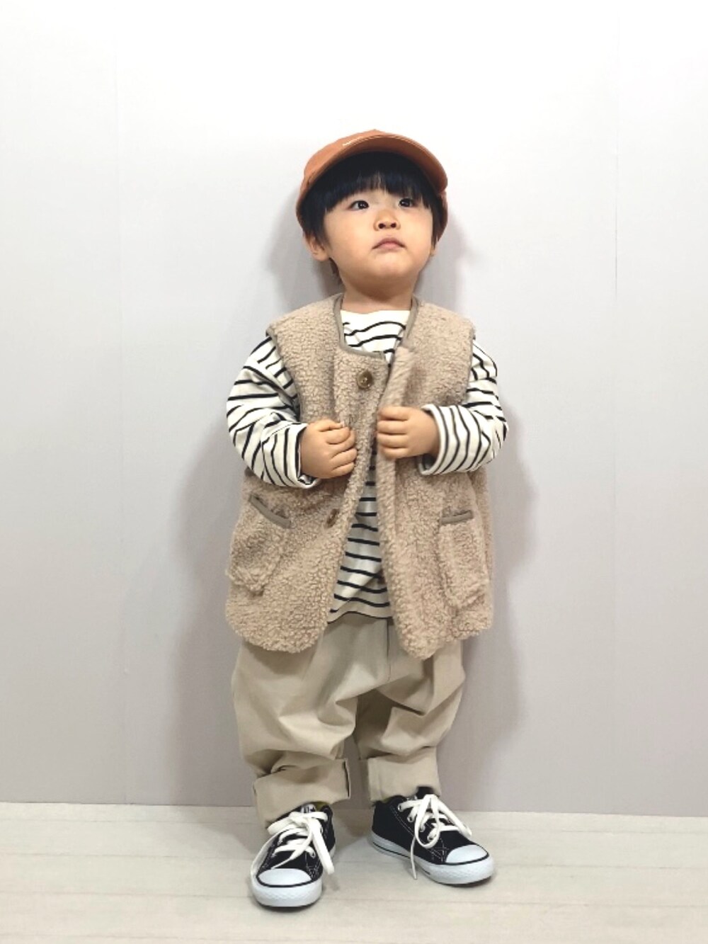 ベージュ系のベスト、ホワイト系のTシャツ/カットソー、ホワイト系のその他パンツを着用したキッズの冬コーディネートの2枚目の写真