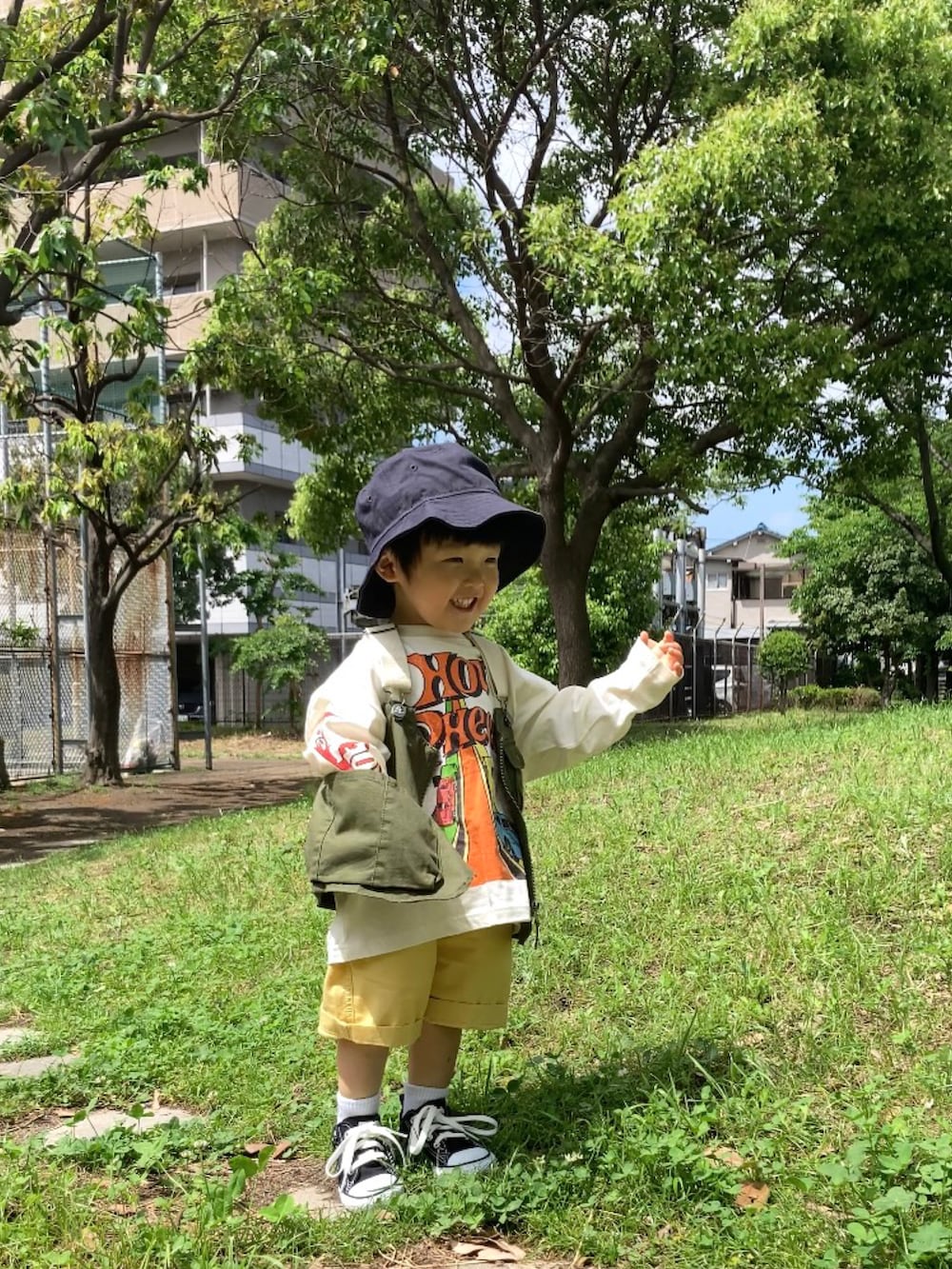 グリーン系のベスト、ホワイト系のTシャツ/カットソー、イエロー系のパンツを着用したキッズの春コーディネートの2枚目の写真