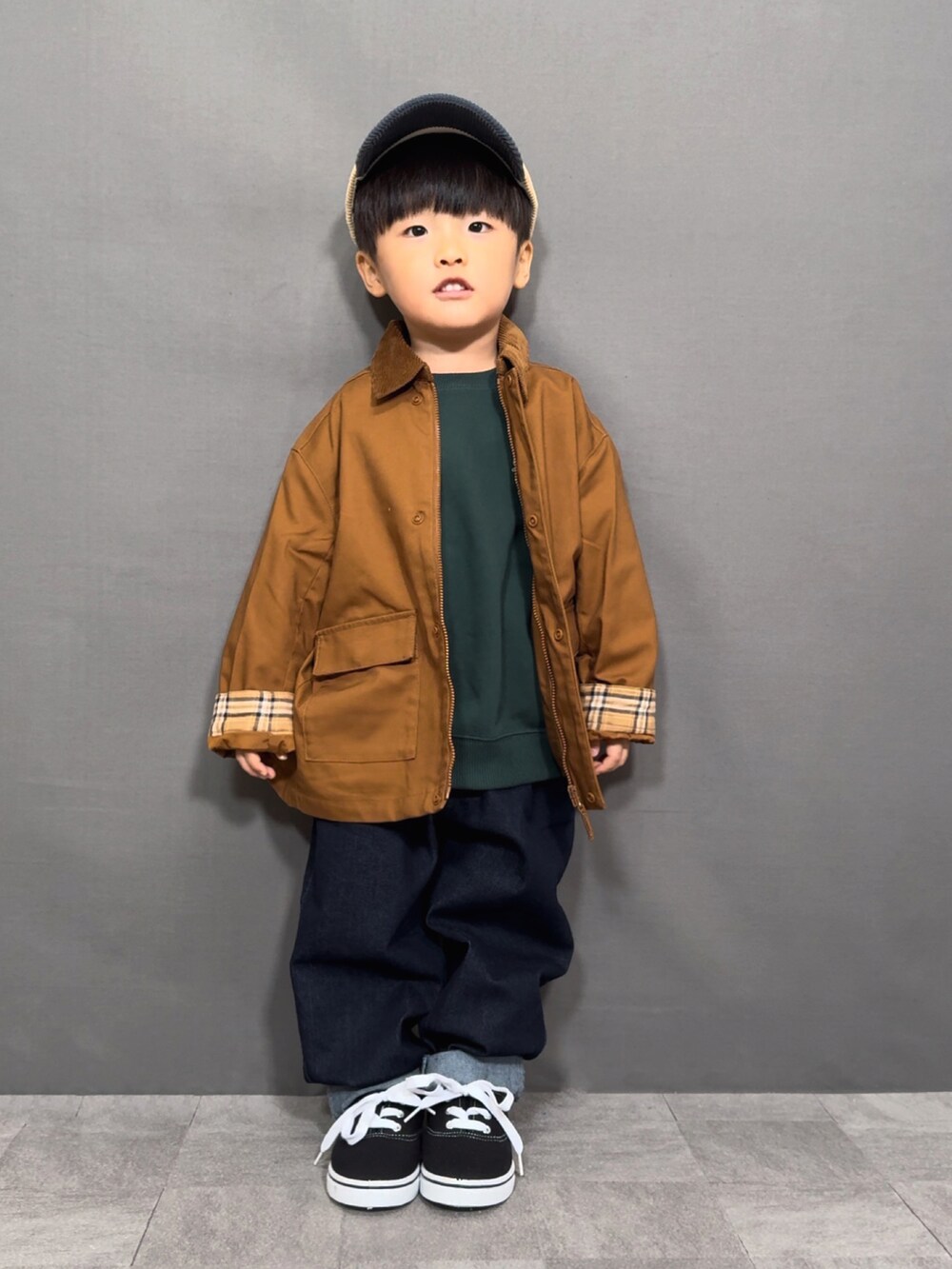 ブラウン系のジャケット/アウター、グリーン系のスウェット、ブルー系のデニムパンツを着用したキッズの秋コーディネートの3枚目の写真