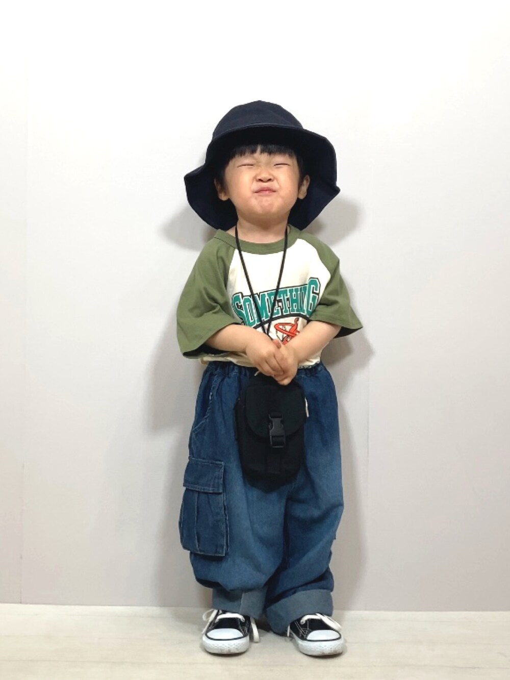 グリーン系のTシャツ/カットソー、ブルー系のデニムパンツ、ブラック系のバッグを着用したキッズの夏コーディネートの4枚目の写真