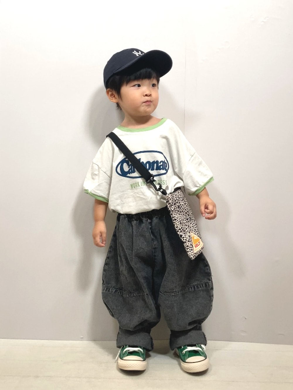 グレー系のTシャツ/カットソー、ブラック系のデニムパンツ、ベージュ系のショルダーバッグを着用したキッズの夏コーディネートの2枚目の写真