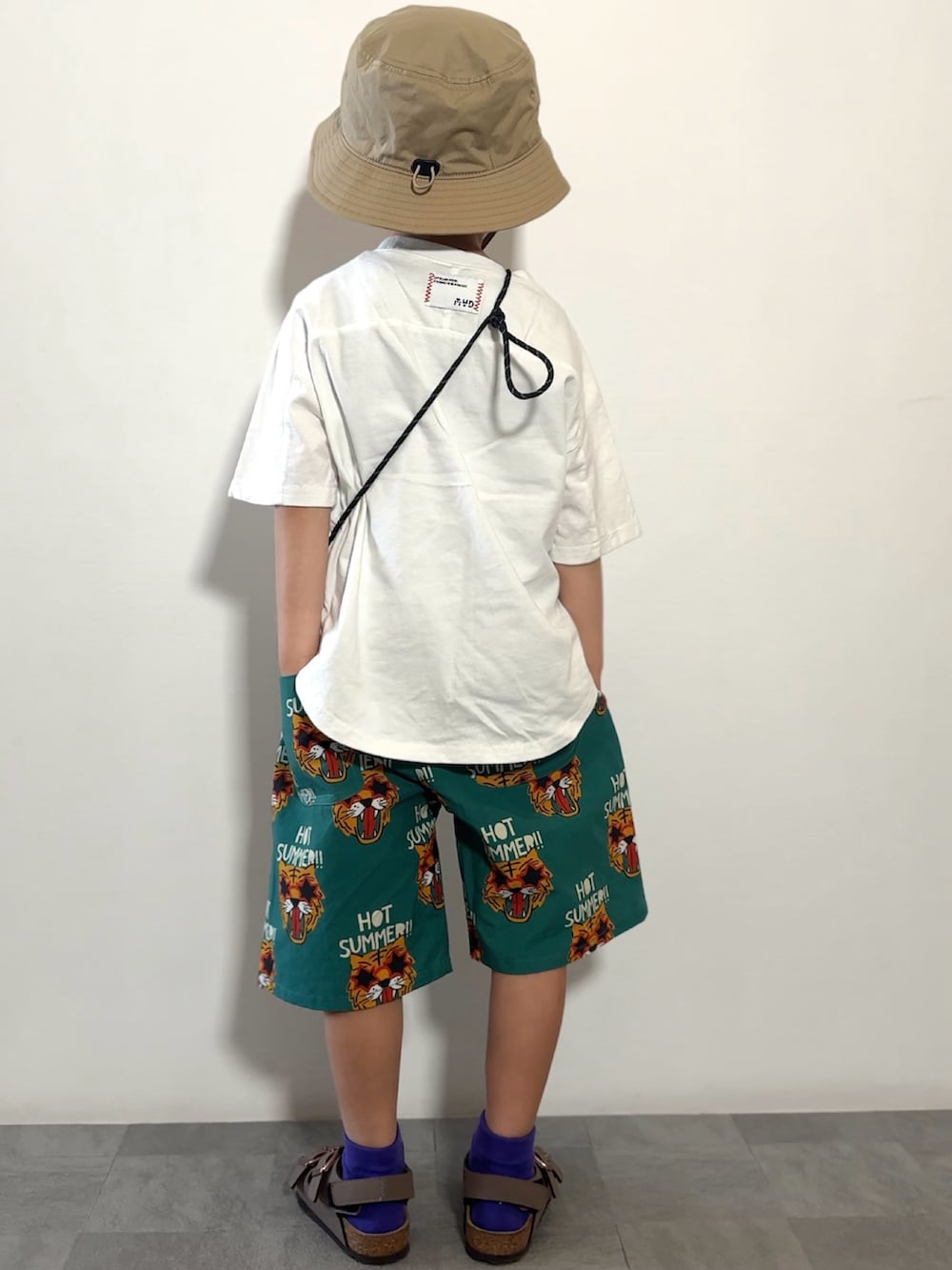 ホワイト系のTシャツ/カットソー、グリーン系のその他パンツ、ブラウン系のサンダルを着用したキッズの春コーディネートの3枚目の写真