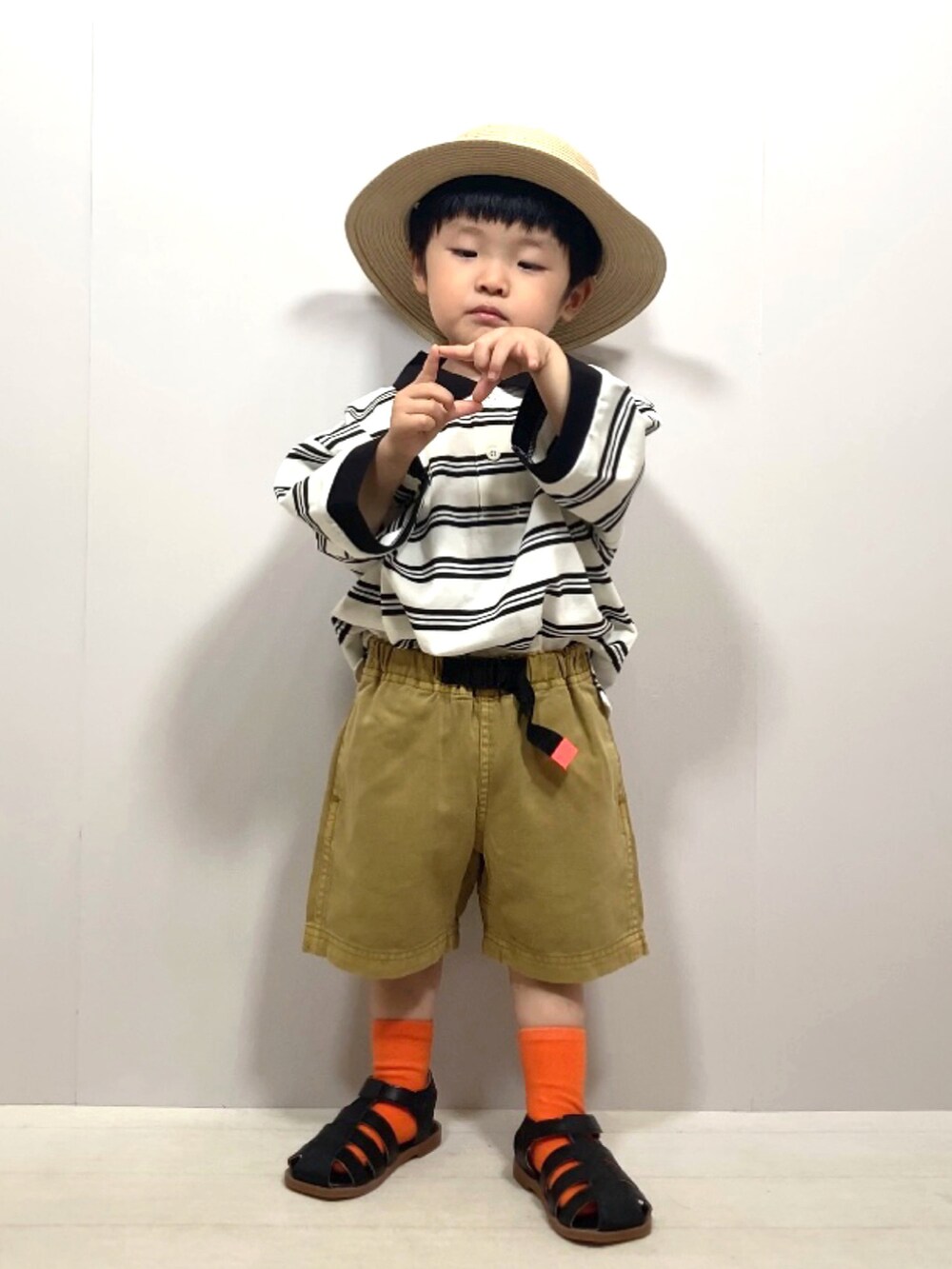 ベージュ系のポロシャツ、イエロー系のその他パンツ、ブラック系のサンダルを着用したキッズの夏コーディネートの4枚目の写真